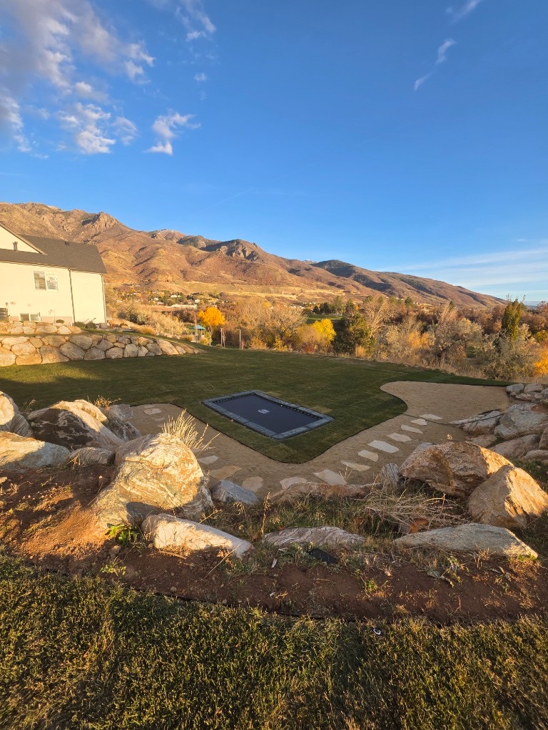 A boulder retaining wall terracing a hillside yard