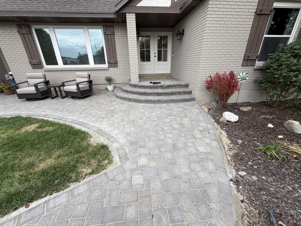A paver front entry walkway with a low seating wall